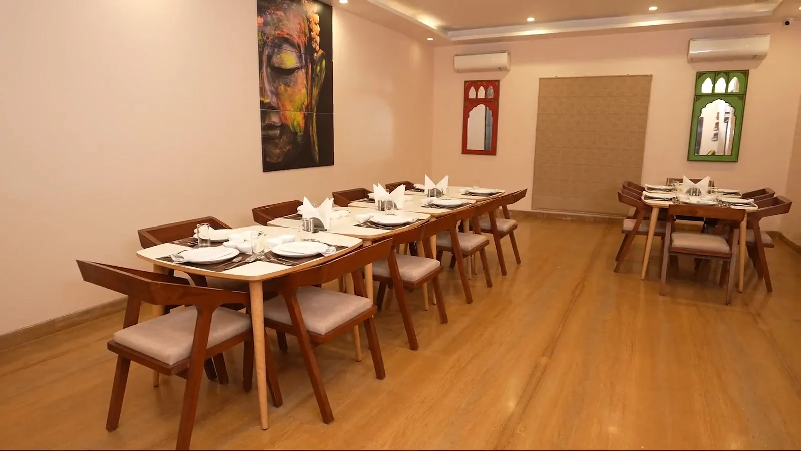 The dining room at Vrindavan Staycation, tables laid with white crockery and napkins