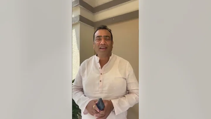 Video still: Mr. Santosh Upadhyay speaking to the camera in a white kurta